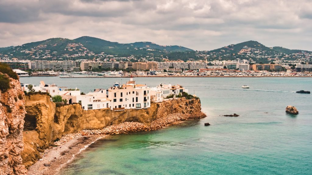 Aerial view of the bay, beach, old houses, of the upper area of Dalt Vila, in Ibiza, Spain, during a stormy day