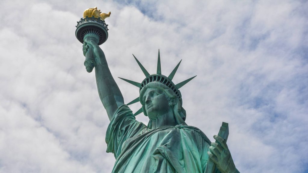 Close-up shot of Statue of Libery with blue sky and clouds in New York
