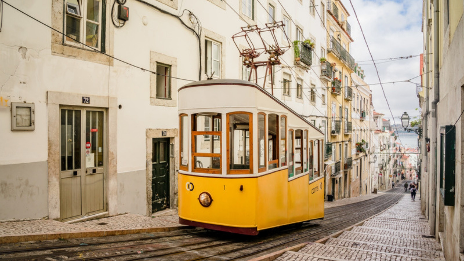 Historic yellow tram in a Lisbon street, living and working in Portugal